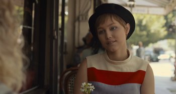 Movie still from “Hollywood Stargirl” (2022), directed by Julia Hart – A woman wearing a hat and holding a flower; Close Up shot, Over the shoulder angle