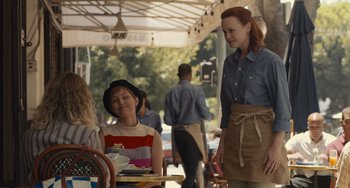 Movie still from “Hollywood Stargirl” (2022), directed by Julia Hart – A woman standing next to a woman sitting at an outdoor table; Medium shot, Over the shoulder angle