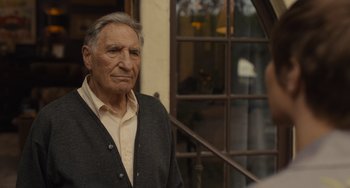 Movie still from “Hollywood Stargirl” (2022), directed by Julia Hart – An older man standing in front of a window; Close Up shot, Over the shoulder angle