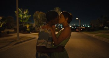 Movie still from “Hollywood Stargirl” (2022), directed by Julia Hart – A man and a woman kissing on the side of a road; Medium shot, High angle