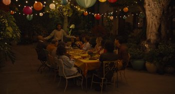 Movie still from “Hollywood Stargirl” (2022), directed by Julia Hart – A group of people sitting around a table at a party; Extreme Wide shot, High angle