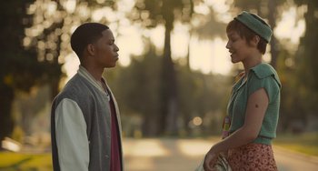 Movie still from “Hollywood Stargirl” (2022), directed by Julia Hart – Two young people standing next to each other in a park; Medium shot, Over the shoulder angle