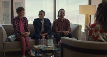 Movie still from “Hollywood Stargirl” (2022), directed by Julia Hart – Two men and a woman sitting on a couch in front of a window; Medium shot, Over the shoulder angle