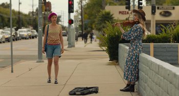 Movie still from “Hollywood Stargirl” (2022), directed by Julia Hart – Two women are playing music on the sidewalk; Wide shot, Over the shoulder angle