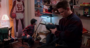 Movie still from “Home Alone” (1990), directed by Chris Columbus – Two young boys are playing baseball in a room; Medium shot, Over the shoulder angle