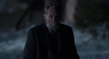 Movie still from “Home Alone” (1990), directed by Chris Columbus – An old man with a beard wearing a black suit; Medium shot, Over the shoulder angle