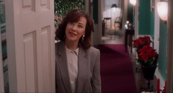 Movie still from “Home Alone” (1990), directed by Chris Columbus – A woman in a gray jacket leaning against a door; Medium shot, Over the shoulder angle
