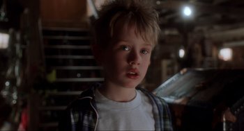 Movie still from “Home Alone” (1990), directed by Chris Columbus – A young boy is standing in front of a staircase; Close Up shot, Low angle