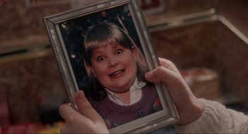 Movie still from “Home Alone” (1990), directed by Chris Columbus – A person holding a picture of a girl with big eyes; Extreme Close Up shot, High angle