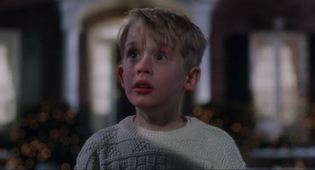 Movie still from “Home Alone” (1990), directed by Chris Columbus – A young boy in a white sweater looking up; Close Up shot, Low angle