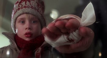 Movie still from “Home Alone” (1990), directed by Chris Columbus – A young child wearing a knitted hat and holding a sock; Extreme Close Up shot, Low angle