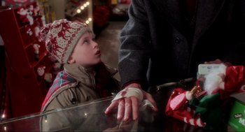 Movie still from “Home Alone” (1990), directed by Chris Columbus – A young boy with bandages on his hands and an older man; Close Up shot, High angle