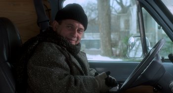 Movie still from “Home Alone” (1990), directed by Chris Columbus – A man sitting in the drivers seat of a car; Medium shot, Low angle