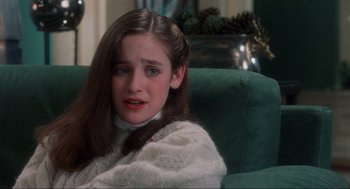 Movie still from “Home Alone” (1990), directed by Chris Columbus – A young girl sitting on a couch crying; Close Up shot, High angle