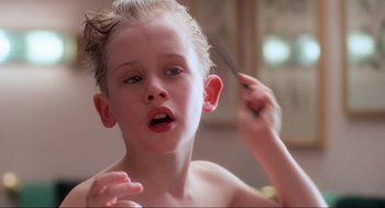 Movie still from “Home Alone” (1990), directed by Chris Columbus – A young boy is combing his hair with a comb; Close Up shot, Low angle