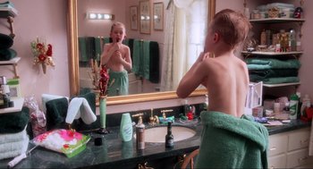 Movie still from “Home Alone” (1990), directed by Chris Columbus – A young boy brushing his teeth in front of a bathroom mirror; Medium shot, Over the shoulder angle