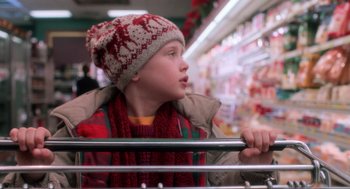Movie still from “Home Alone” (1990), directed by Chris Columbus – A young boy wearing a hat and scarf in a grocery store; Close Up shot, Over the shoulder angle
