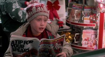Movie still from “Home Alone” (1990), directed by Chris Columbus – A young boy reading a magazine in a store; Close Up shot, High angle