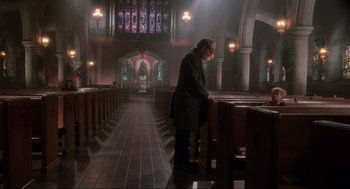 Movie still from “Home Alone” (1990), directed by Chris Columbus – A man standing in front of pews in a church; Extreme Wide shot, Low angle