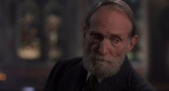 Movie still from “Home Alone” (1990), directed by Chris Columbus – An old man with a beard and a suit; Close Up shot, Over the shoulder angle