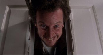 Movie still from “Home Alone” (1990), directed by Chris Columbus – A person smiling for the camera; Close Up shot, Overhead angle