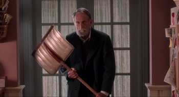 Movie still from “Home Alone” (1990), directed by Chris Columbus – An older man holding a large wooden spatula; Medium shot, Low angle