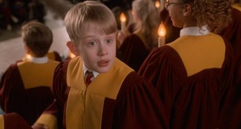 Movie still from “Home Alone 2: Lost in New York” (1992), directed by Chris Columbus – A young boy in a red and yellow graduation gown; Close Up shot, Low angle