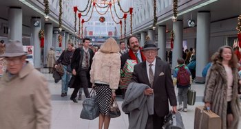 Movie still from “Home Alone 2: Lost in New York” (1992), directed by Chris Columbus – A group of people walking in a mall with bags; Wide shot, Over the shoulder angle