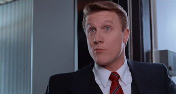 Movie still from “Home Alone 2: Lost in New York” (1992), directed by Chris Columbus – A person wearing a suit and red tie; Close Up shot, Low angle