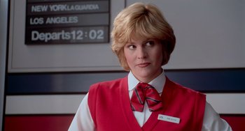 Movie still from “Home Alone 2: Lost in New York” (1992), directed by Chris Columbus – A woman wearing a red vest and a red tie; Close Up shot, Low angle