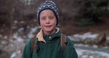 Movie still from “Home Alone 2: Lost in New York” (1992), directed by Chris Columbus – A young boy wearing a green jacket and a blue hat; Close Up shot, High angle