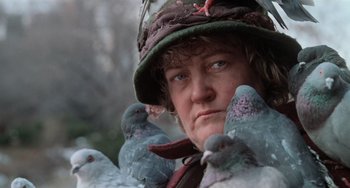 Movie still from “Home Alone 2: Lost in New York” (1992), directed by Chris Columbus – A man with a hat and a bunch of pigeons; Close Up shot, Low angle