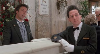 Movie still from “Home Alone 2: Lost in New York” (1992), directed by Chris Columbus – A man in a tuxedo sitting next to another man in a suit and tie; Medium shot, Low angle