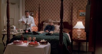 Movie still from “Home Alone 2: Lost in New York” (1992), directed by Chris Columbus – Two people sitting on a four poster bed in a hotel room; Wide shot, High angle