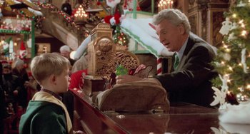 Movie still from “Home Alone 2: Lost in New York” (1992), directed by Chris Columbus – An older man and a young boy playing a game on a piano; Medium shot, Over the shoulder angle