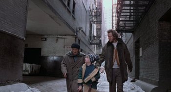 Movie still from “Home Alone 2: Lost in New York” (1992), directed by Chris Columbus – Three men walking down a street in a city; Wide shot, Over the shoulder angle