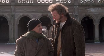 Movie still from “Home Alone 2: Lost in New York” (1992), directed by Chris Columbus – A man and a woman standing next to each other; Medium shot, Over the shoulder angle