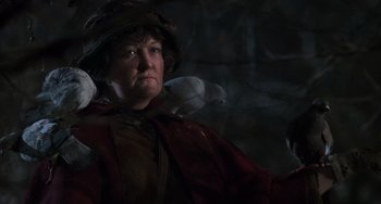 Movie still from “Home Alone 2: Lost in New York” (1992), directed by Chris Columbus – An older woman with a bird in her hand; Close Up shot, Low angle