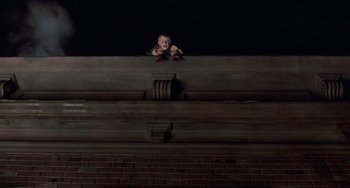 Movie still from “Home Alone 2: Lost in New York” (1992), directed by Chris Columbus – A small child sitting on top of a stair railing at night; Wide shot, Low angle