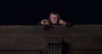 Movie still from “Home Alone 2: Lost in New York” (1992), directed by Chris Columbus – A young boy looking over the top of a building; Medium shot, Low angle