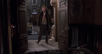 Movie still from “Home Alone 2: Lost in New York” (1992), directed by Chris Columbus – A man walking in front of a door way; Wide shot, High angle
