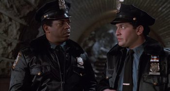 Movie still from “Home Alone 2: Lost in New York” (1992), directed by Chris Columbus – Two police officers are talking to one another; Medium shot, Over the shoulder angle