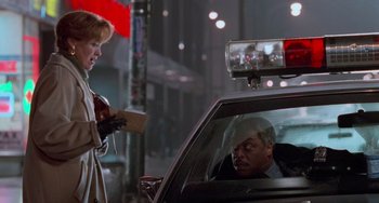 Movie still from “Home Alone 2: Lost in New York” (1992), directed by Chris Columbus – A man sitting in the back seat of a police car; Medium shot, Low angle