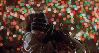 Movie still from “Home Alone 2: Lost in New York” (1992), directed by Chris Columbus – Two children are hugging in front of a colorful background; Close Up shot, Low angle
