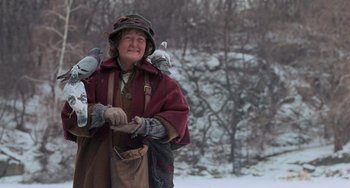 Movie still from “Home Alone 2: Lost in New York” (1992), directed by Chris Columbus – An older woman holding two pigeons on her shoulder; Medium shot, Low angle