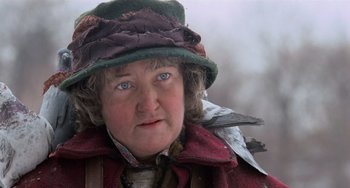 Movie still from “Home Alone 2: Lost in New York” (1992), directed by Chris Columbus – An older woman wearing a hat with a bird perched on her shoulder; Close Up shot, Low angle