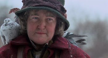 Movie still from “Home Alone 2: Lost in New York” (1992), directed by Chris Columbus – An older woman wearing a green hat and a red coat; Close Up shot, Low angle