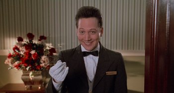 Movie still from “Home Alone 2: Lost in New York” (1992), directed by Chris Columbus – A man in a suit and tie holding a white gloved hand; Close Up shot, Low angle