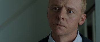 Movie still from “Hot Fuzz” (2007), directed by Edgar Wright – A person wearing a suit and tie; Close Up shot, Over the shoulder angle