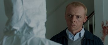 Movie still from “Hot Fuzz” (2007), directed by Edgar Wright – A man looking at himself in the mirror; Close Up shot, Over the shoulder angle